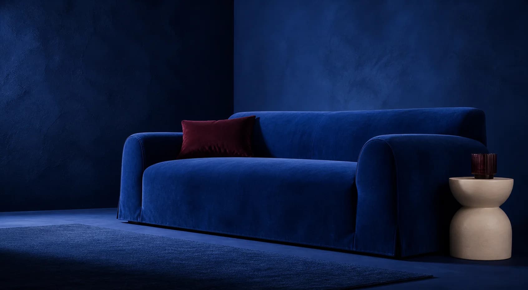 Canapé habillé d’une housse bleu cobalt dans un décor studio