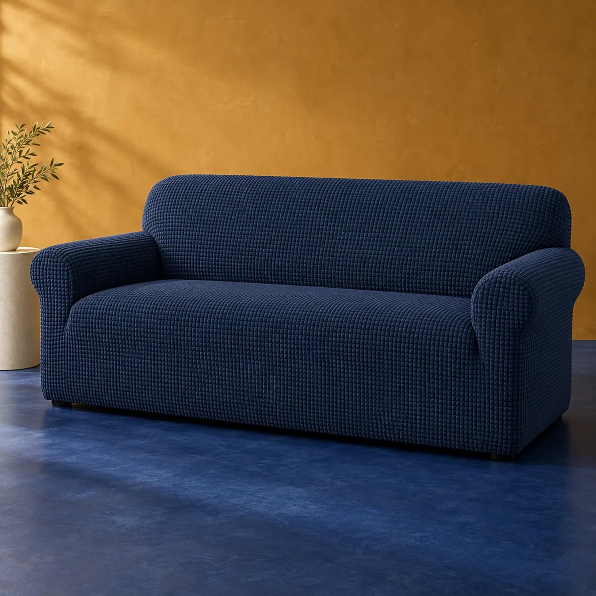 Canapé trois places habillé d’une maille gaufrée bleu nuit dans un studio Housees