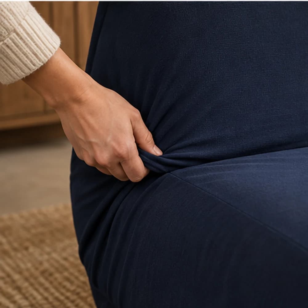 Main ajustant la housse au pli du futon